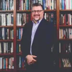 Professional photo of Kevin McMahon in front of bookcase