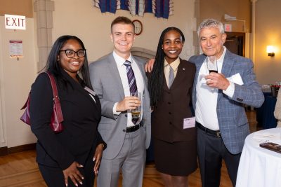Alumni and student smiling