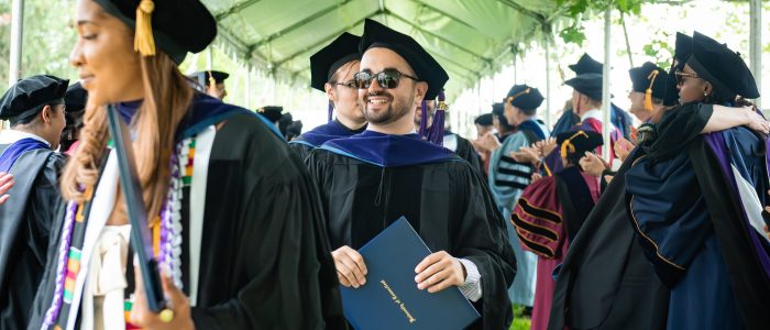 Three graduates walking into the ceremony